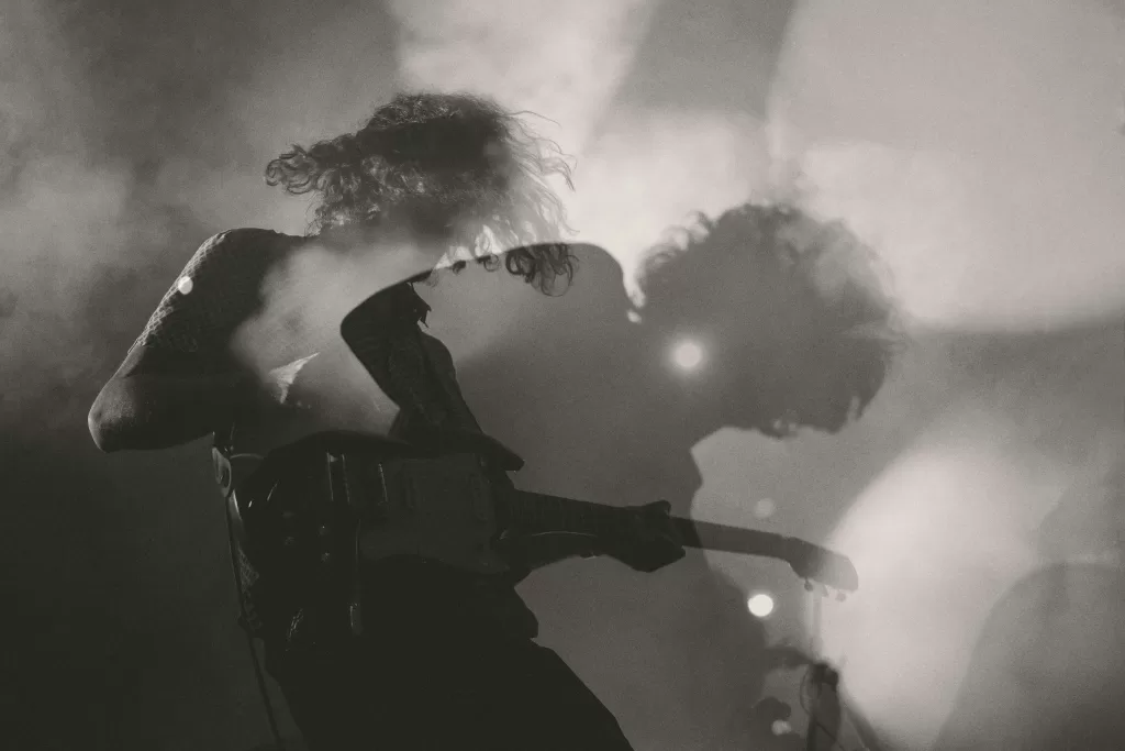 A musician playing guitar in black and white