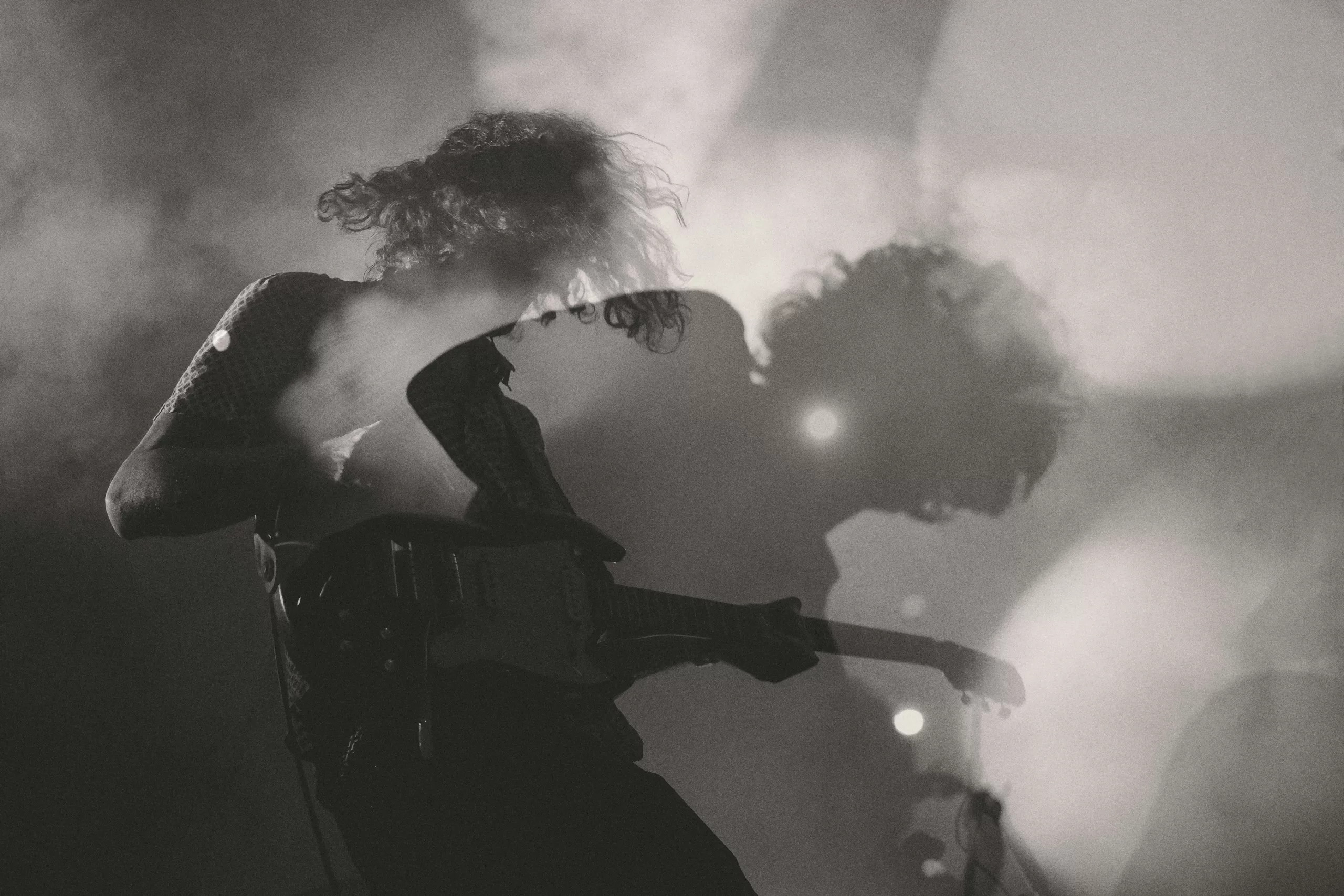 A musician playing guitar in black and white
